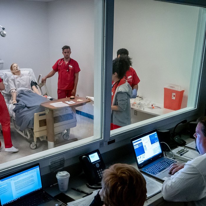 Nursing faculty oversee students through a one-way mirror