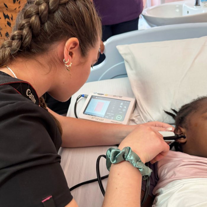 Audiology student Emma Simas conducts an auditory brainstem response screening on a baby.