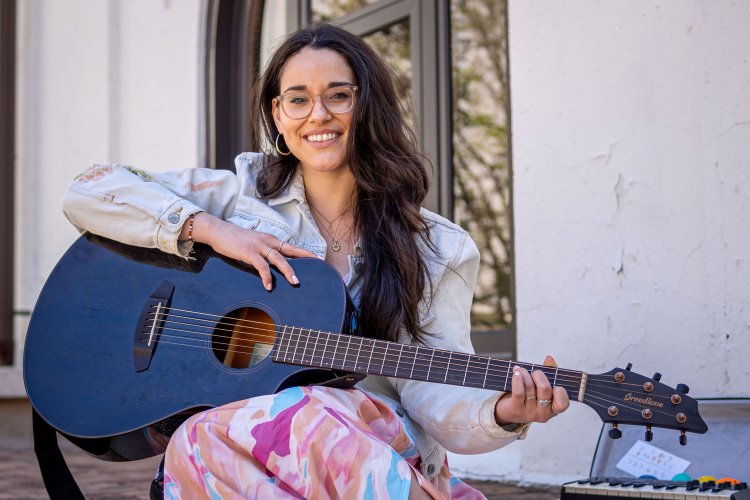 Alyssa Muñiz holds a guitar.