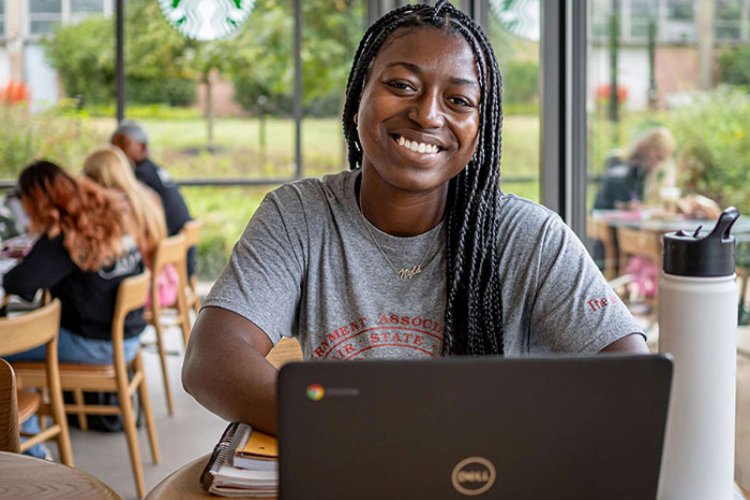 Woman smiling in front of a computer. 