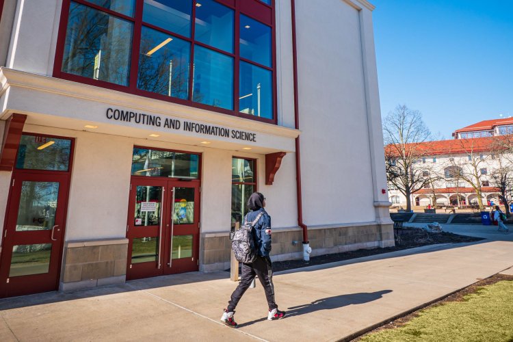 Student walking past the entrance of the Center for Computing and Information Science