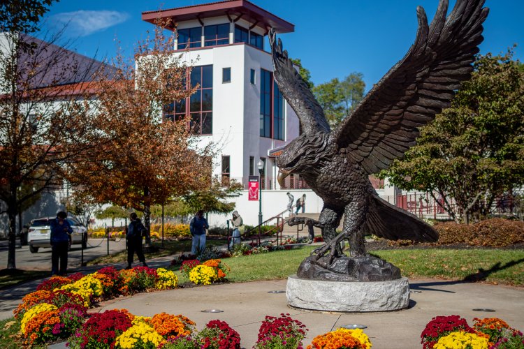 An image of the Montclair Red Hawk statue with students and the Kasser Theater in the background.