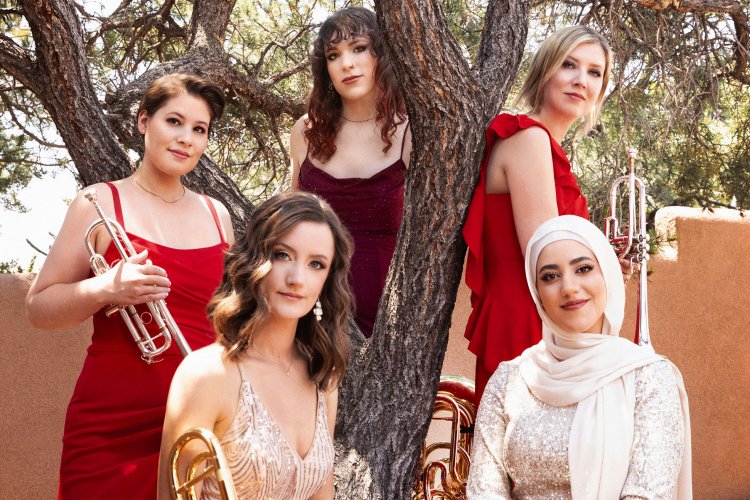 Members of Seraph Brass with instruments outside around a tree
