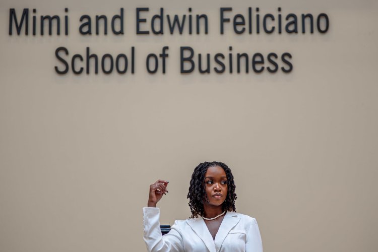 School of Business Student Posing in Front of School Name