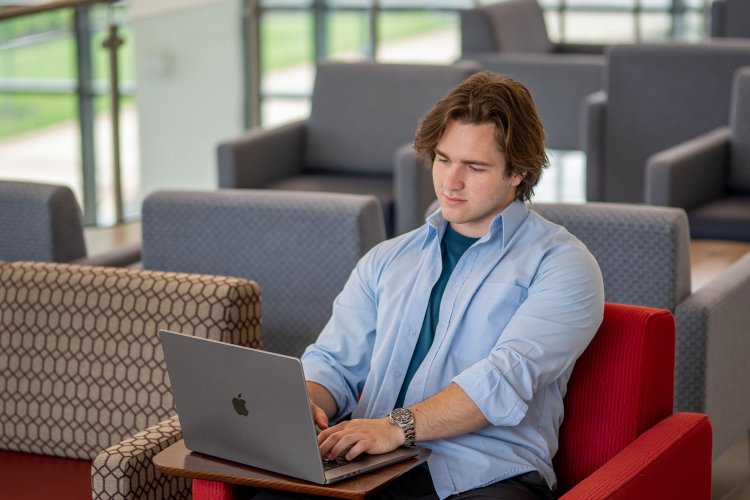 Student with laptop in a lounge