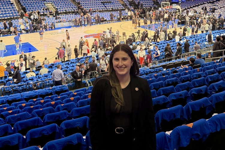 Emily Swedelson standing in the stands at Madison Square Garden with the court in the background.