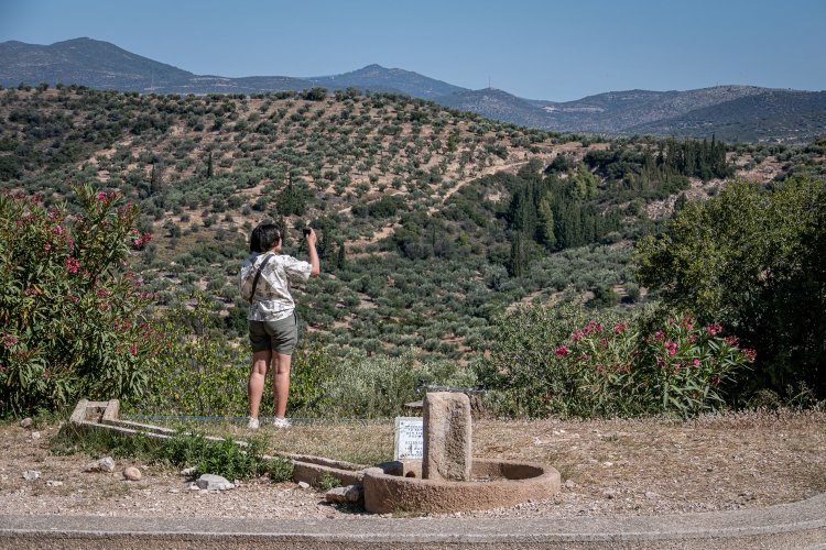 A student taking a photo of hills in Greece.