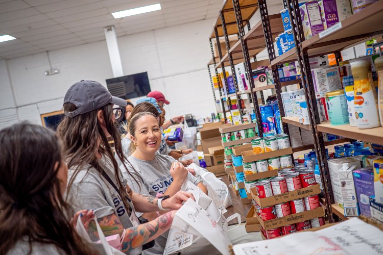 Students organizing food and supplies on shelves.