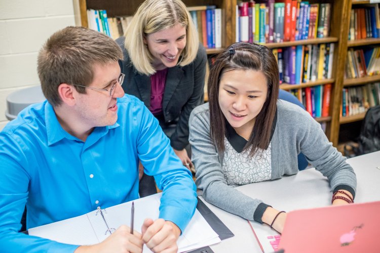 Two students in discussion with instructor
