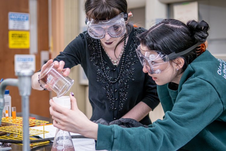 students holding beakers in chemistry lab