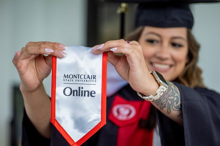 Online degree graduate holds stole reading Montclair State University Online