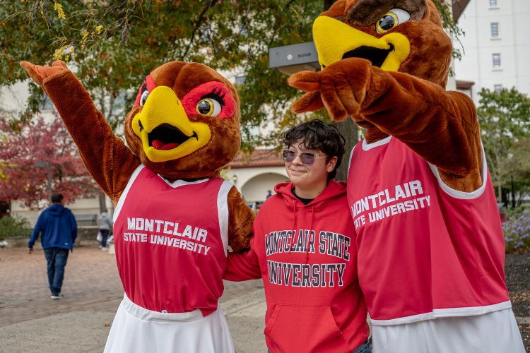 Rocky and Roxy the Red Hawks pose with student at Open House