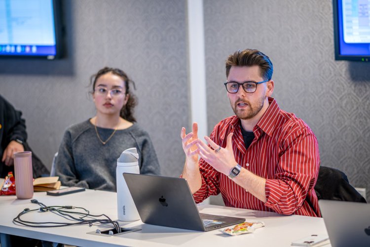 Strategic communication student leading discussion on laptop
