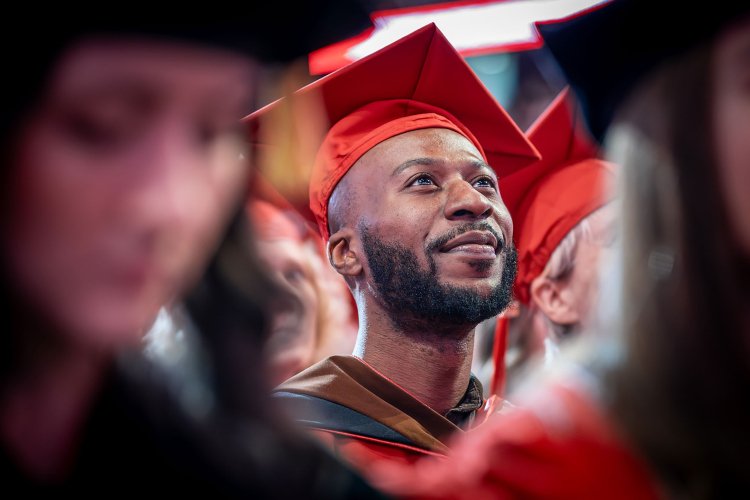 Malcolm McMichael in red cap and gown at Montclair State University 2026 Commencement.