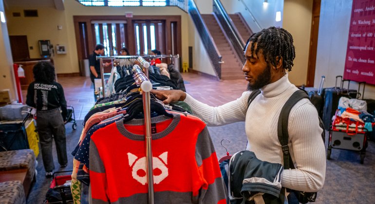 Rockys closet pop up while a student looks at a clothing rack. 