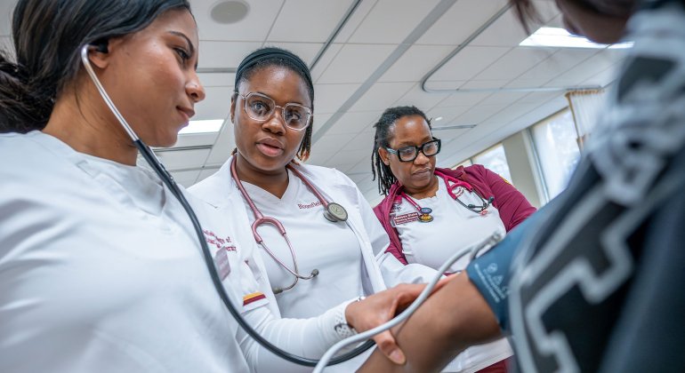Bloomfield Nursing students assessing blood pressure of a patient