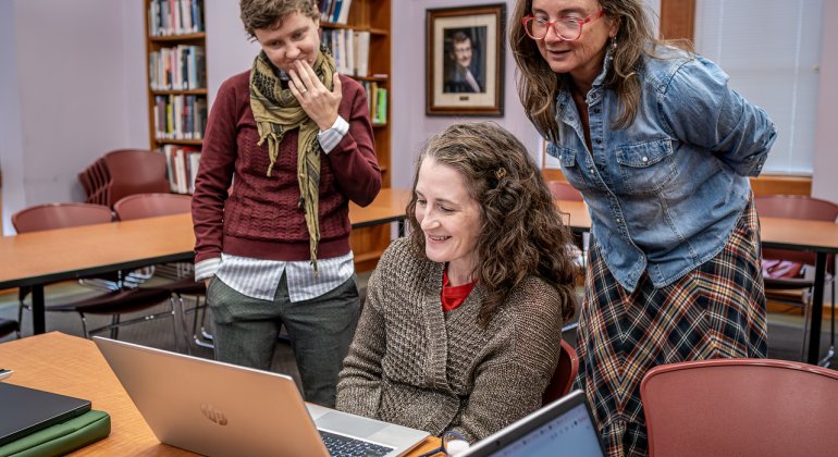 Students Working With Faculty at Laptop