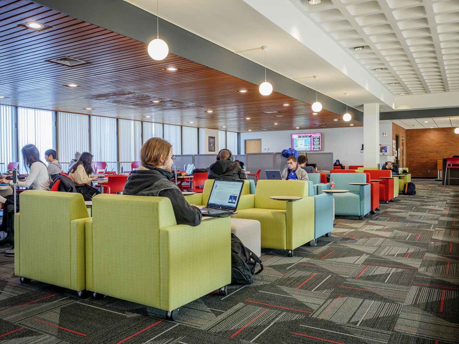 students in a lounge area with bright colored armchairs