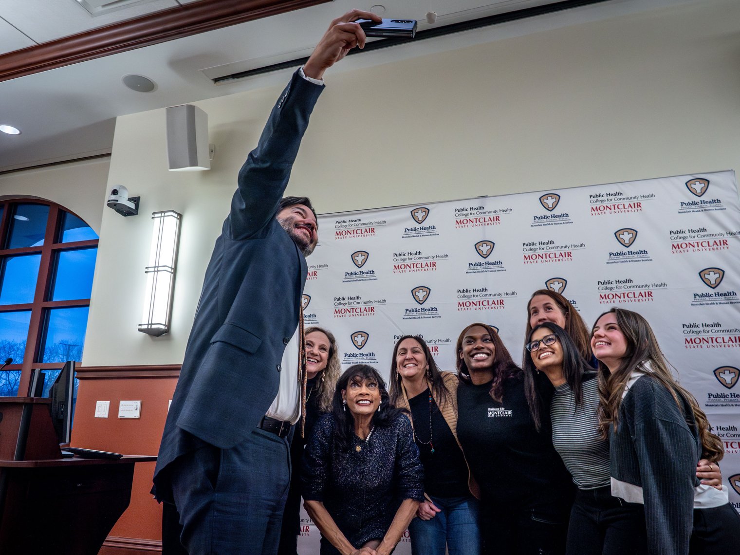 A group of Montclair faculty and students and Montclair Township Mayor Renee Baskerville pose for a selfie taken by President Jonathan Koppell.