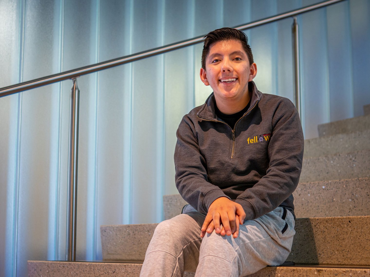 Male student sits on steps.
