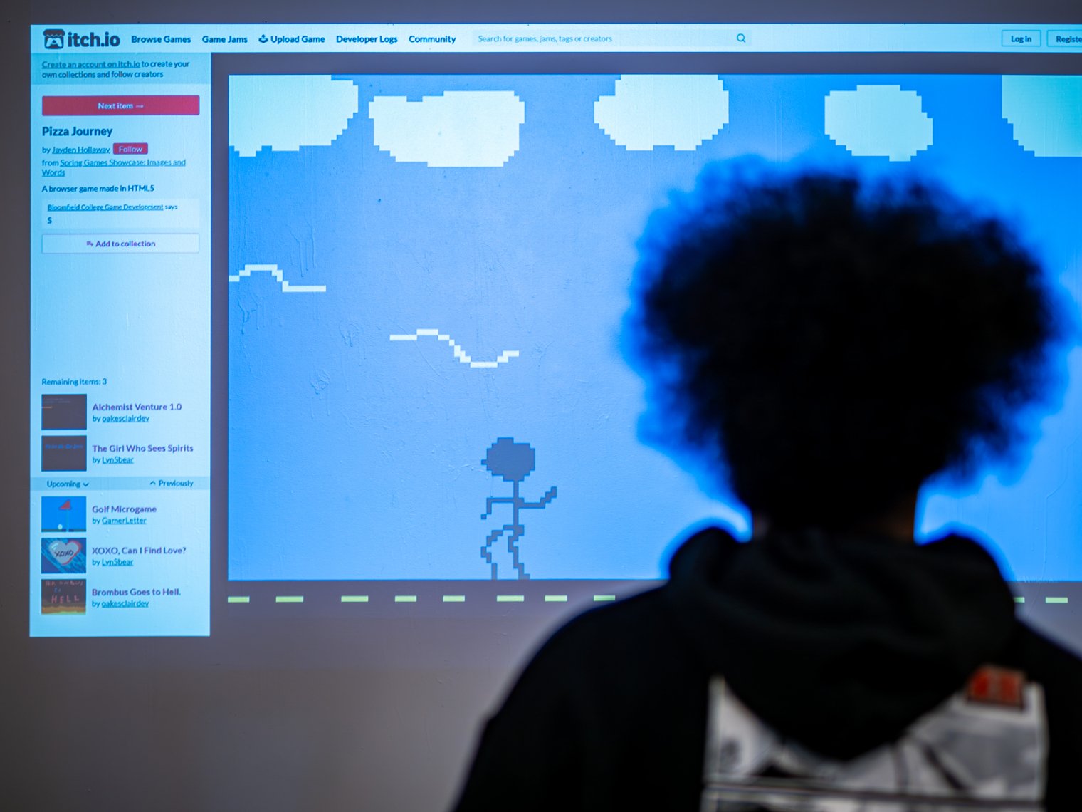 Woman is pictured in front of a projector playing a game.