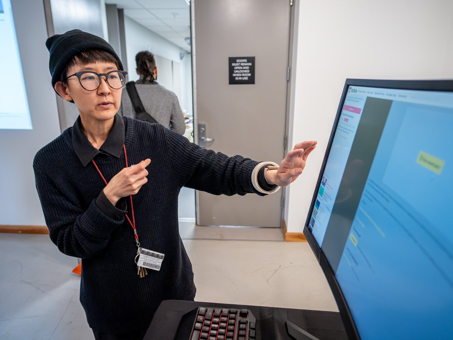 Woman is presenting something on screen. 