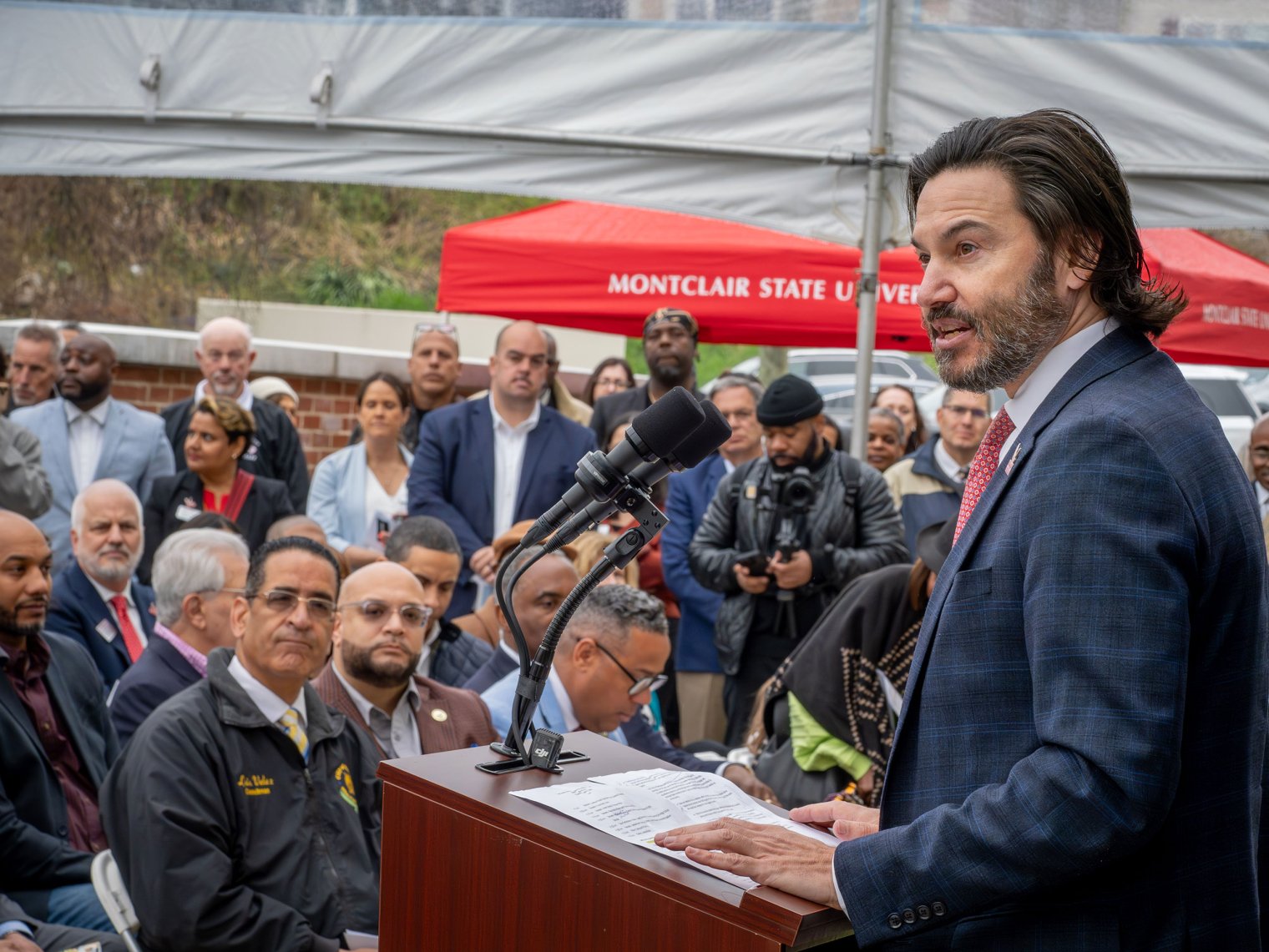 Jonathan Koppell speaks to the crowd inside a tent.
