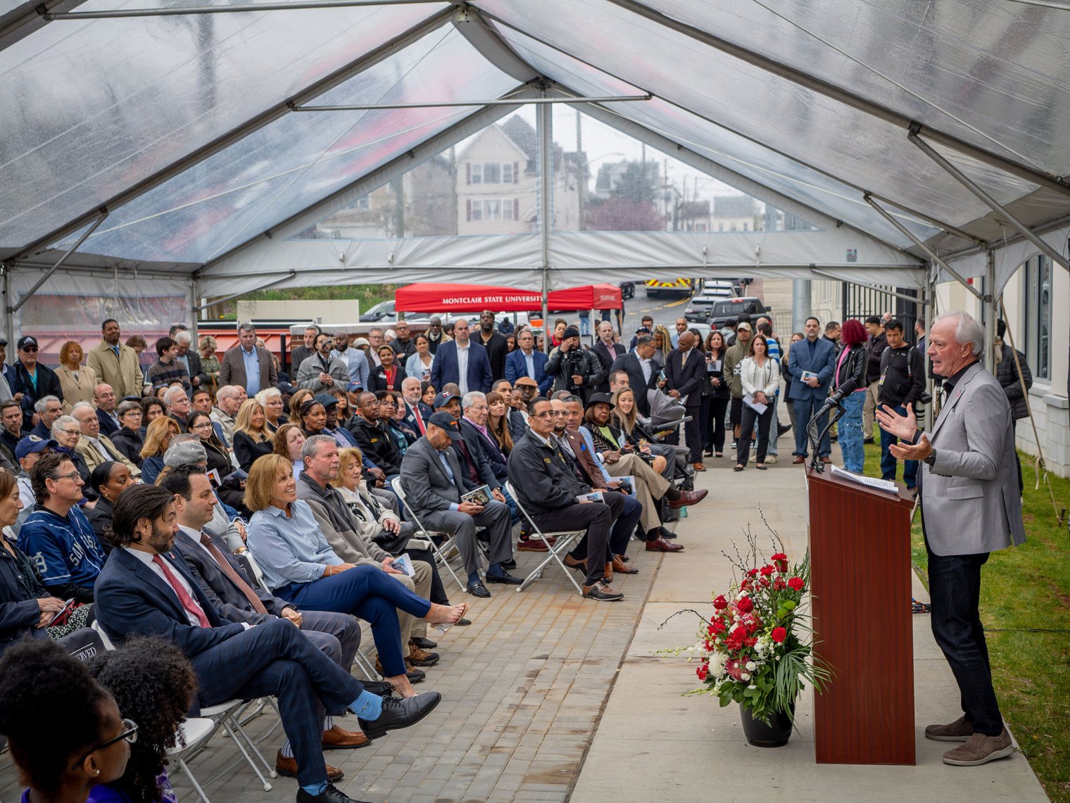 Charles J. Muth speaks to the crowd inside a tent.