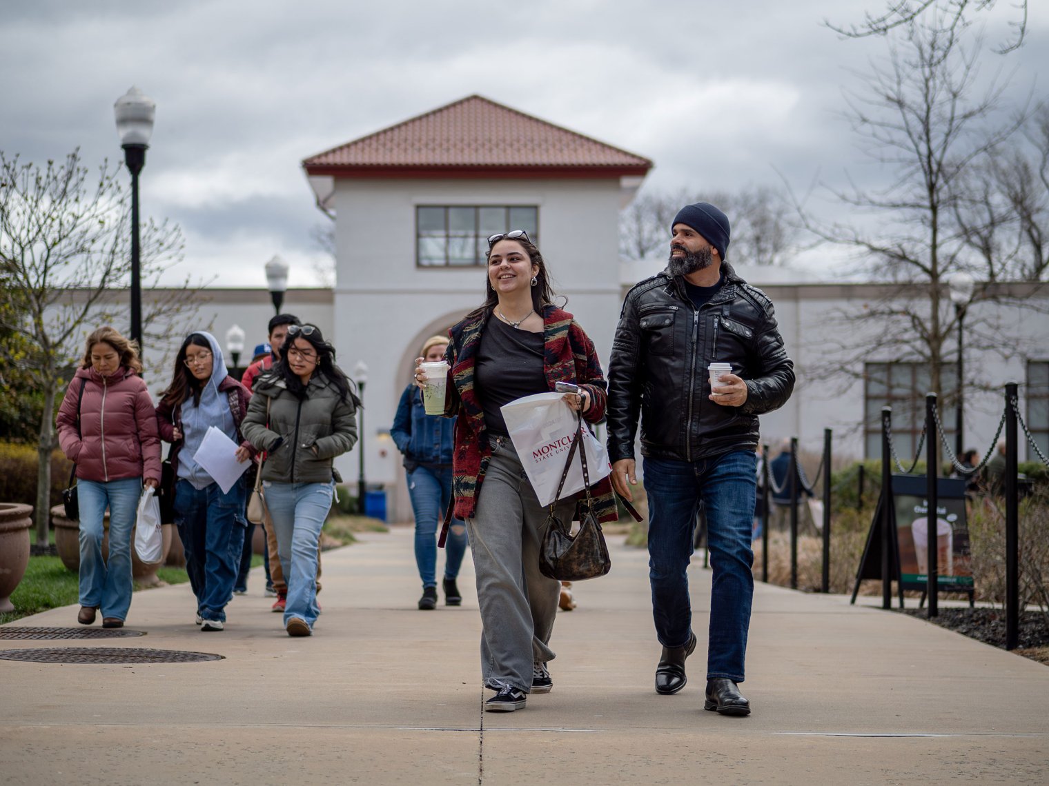 Groups of students and parents walk along a campus pathway during Montclair State University’s Accepted Student Day.