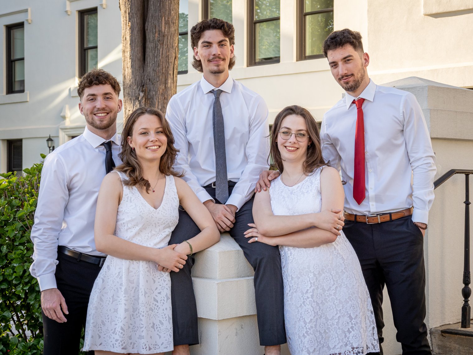 The Povolo quintuplets pose before a white building