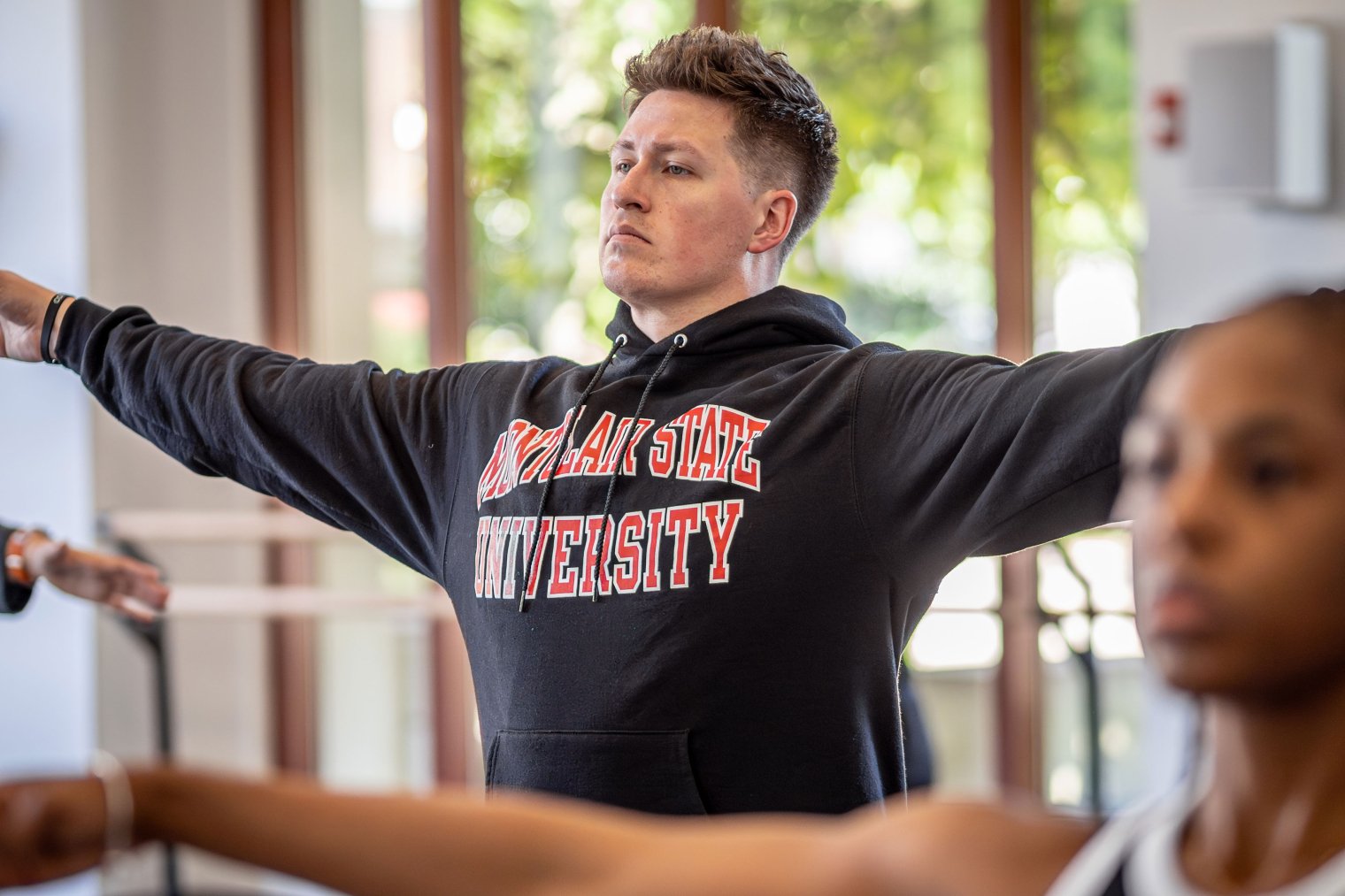 MFA Dance students in studio with arms outstretched.