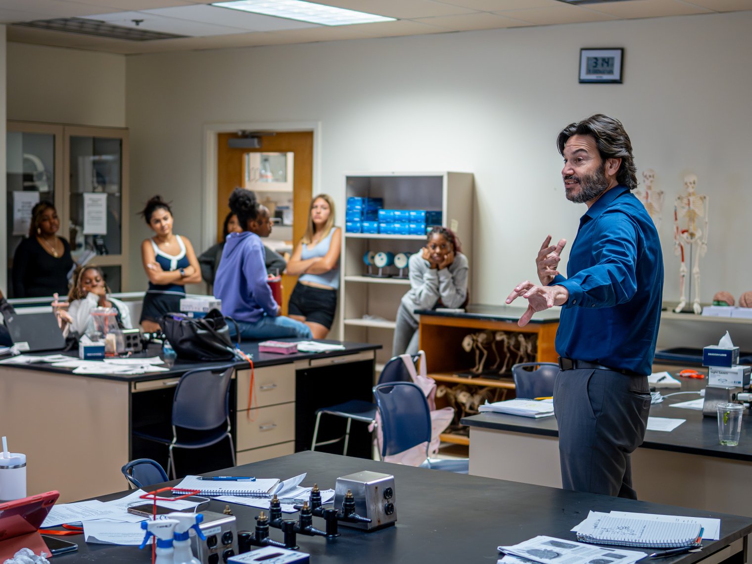 A teacher teaching in front of a classroom. 