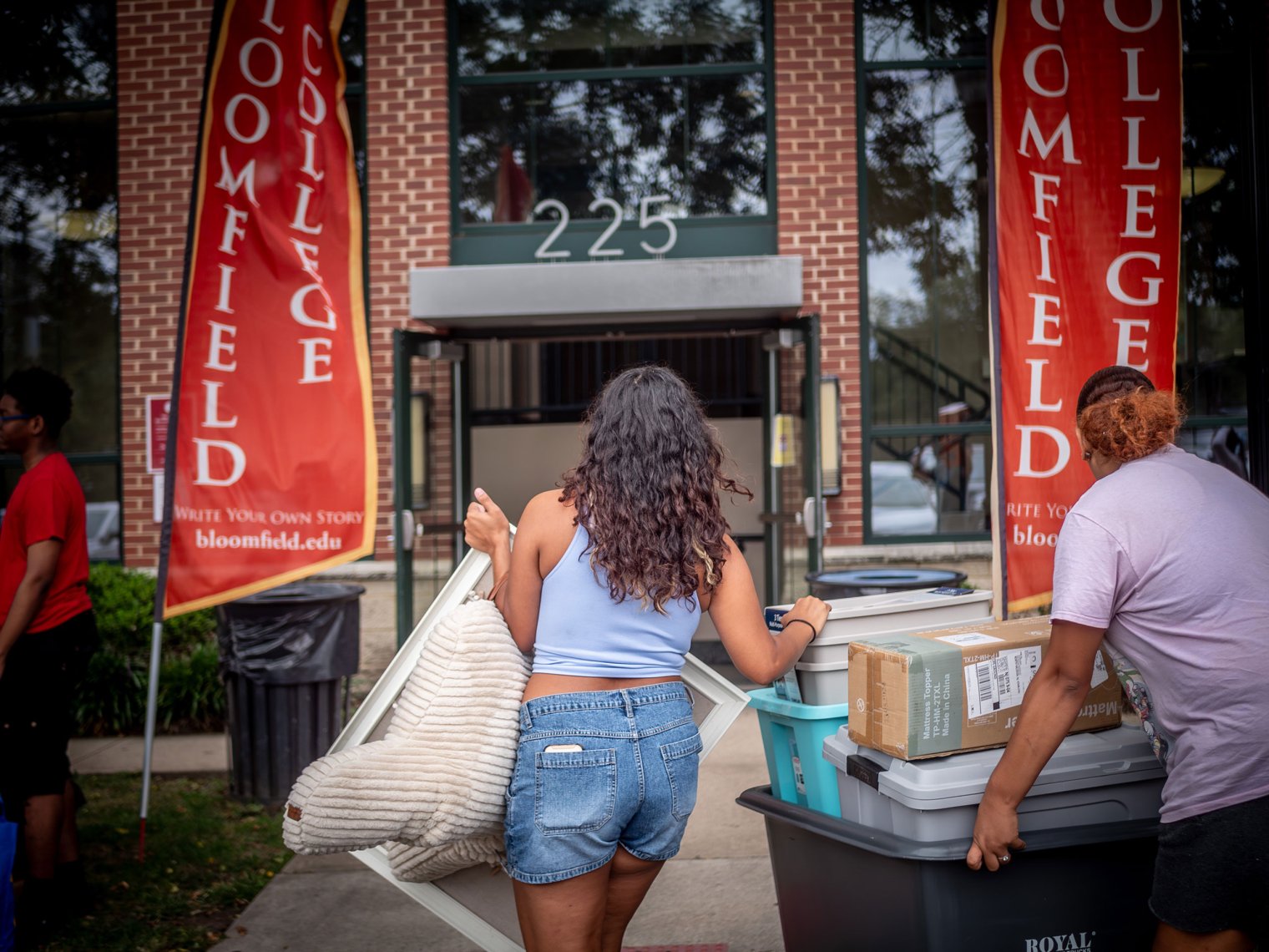 Woman is seen moving into a dorm. 
