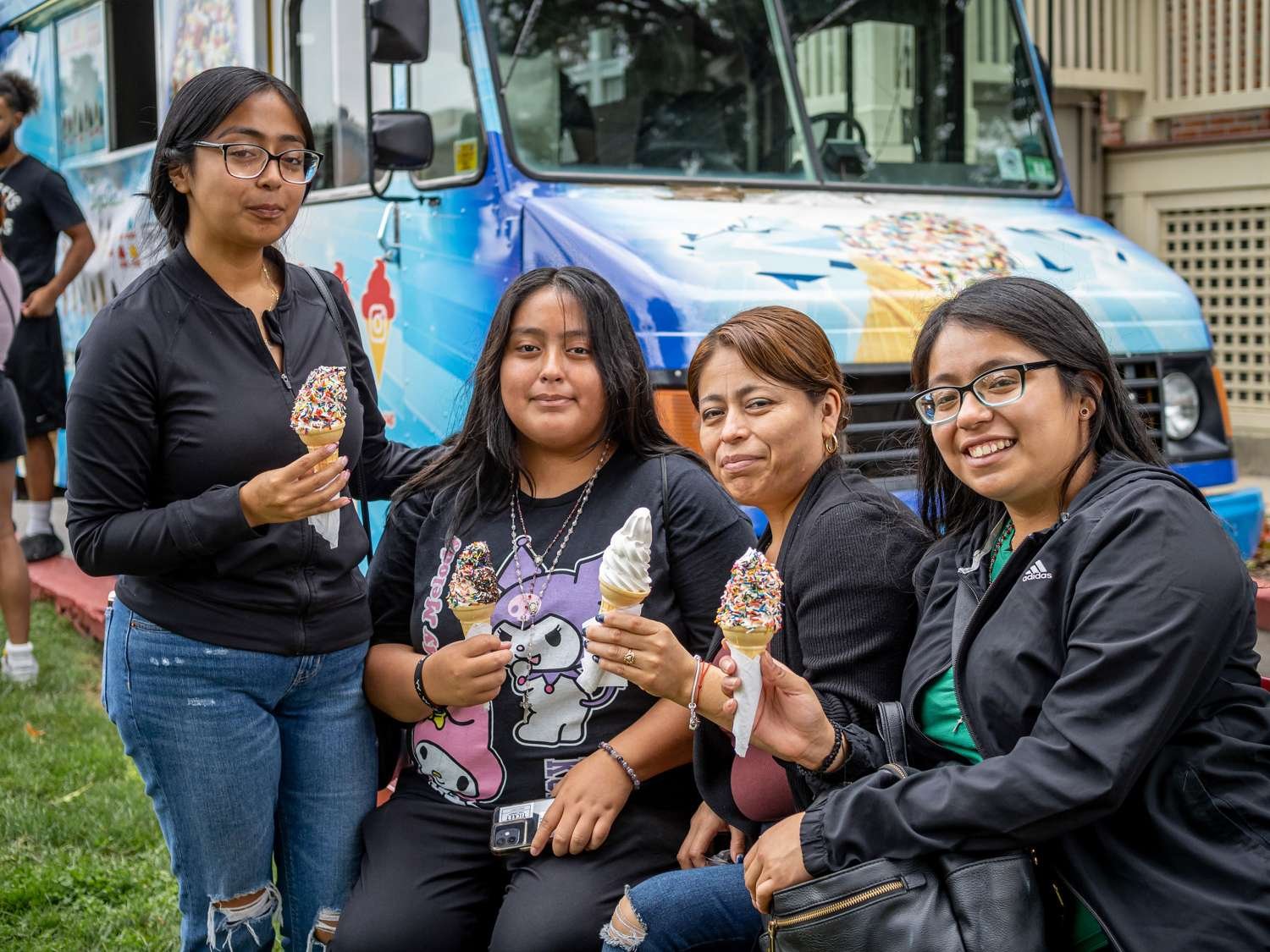 Four women are posing with their ice cream cones. 
