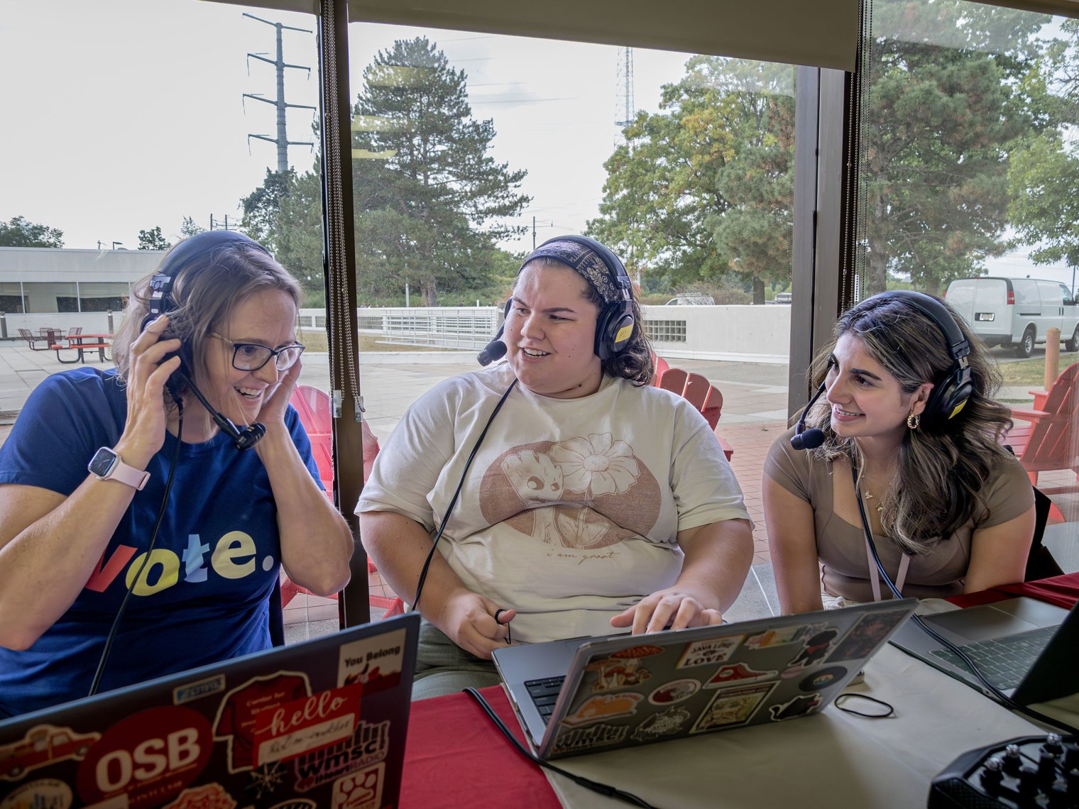 Assemblywoman Andrea Katz (D-District 8) speaking into a microphone while being interviewed by two students from WMSC 90.3-FM during National Voter Registration Day at Montclair State University.