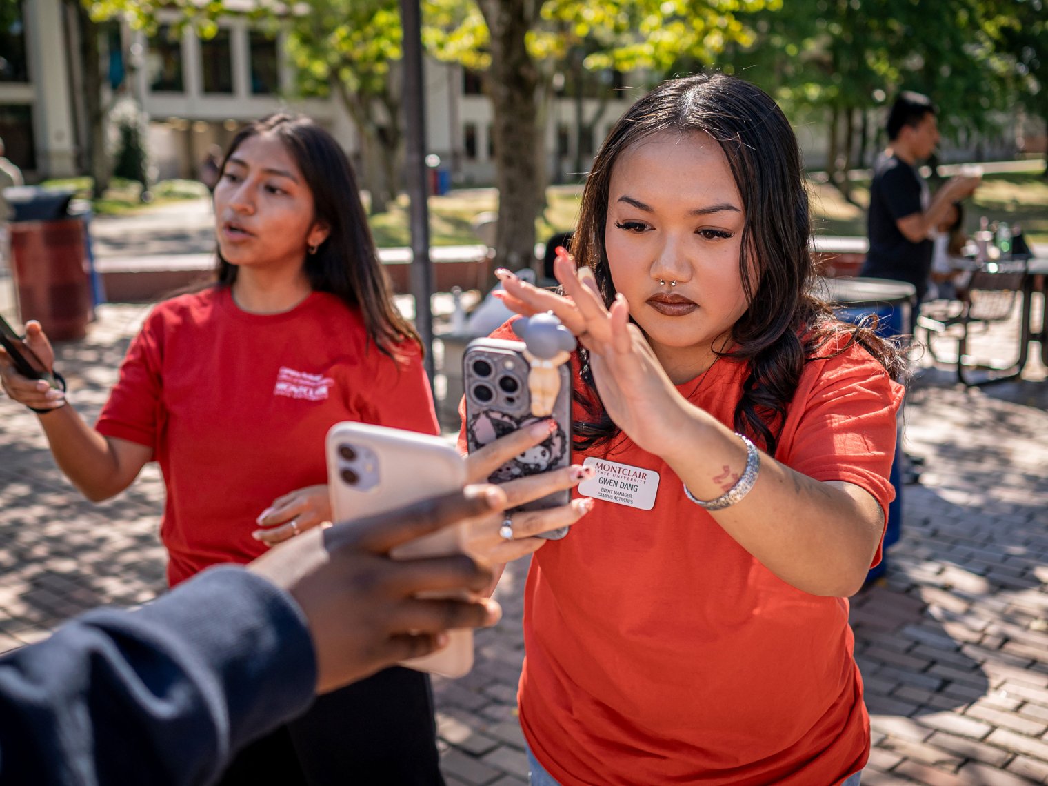 Gwen Dang scans a phone to register a student at a Commuter Life event.