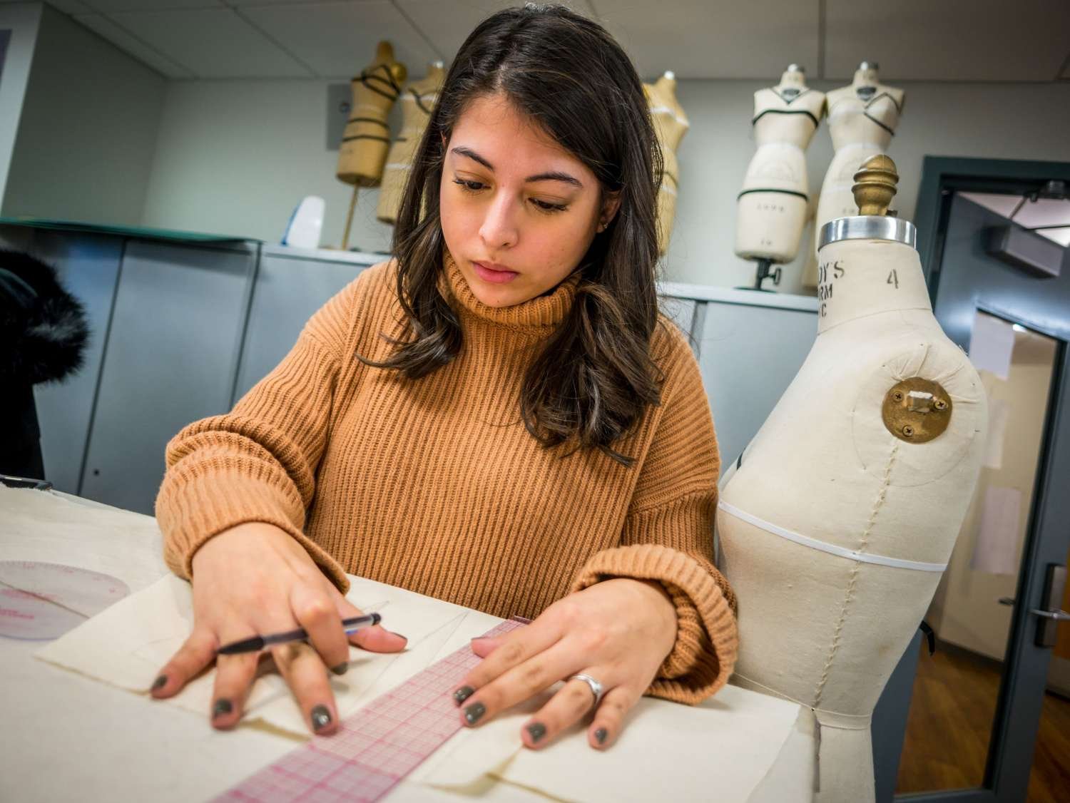 Fashion design student sketching on fabric.