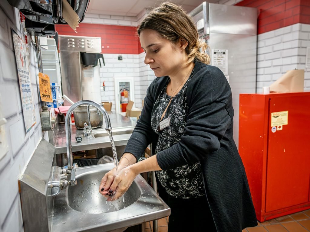 Woman washing her hands at a sink. 