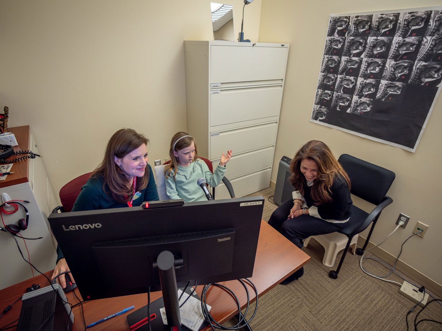 Alexis Gallegher works with Collet at a computer as Elaine Hitchcock looks on.