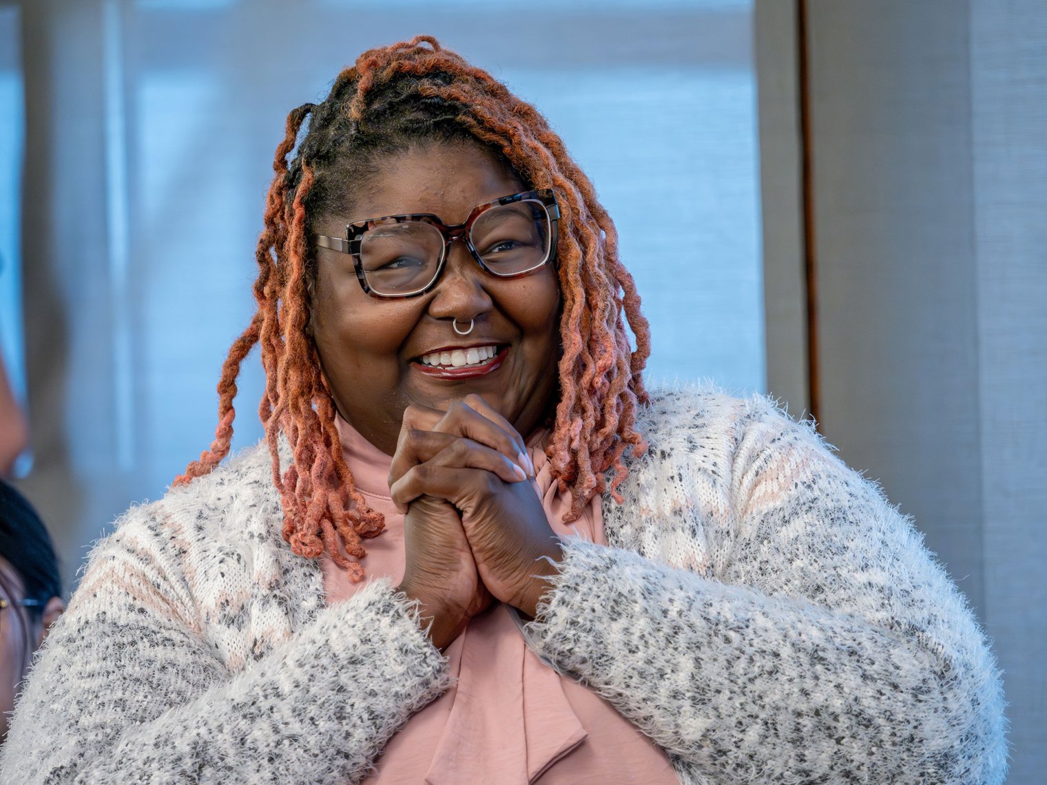 Khara Brown clasps her hands and smiles upon receiving an award at the Women's Leadership Conference.
