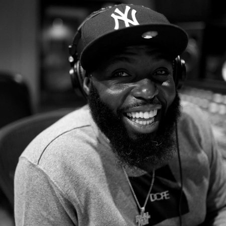 Man with a hat and beard is pictured smiling at the camera. 