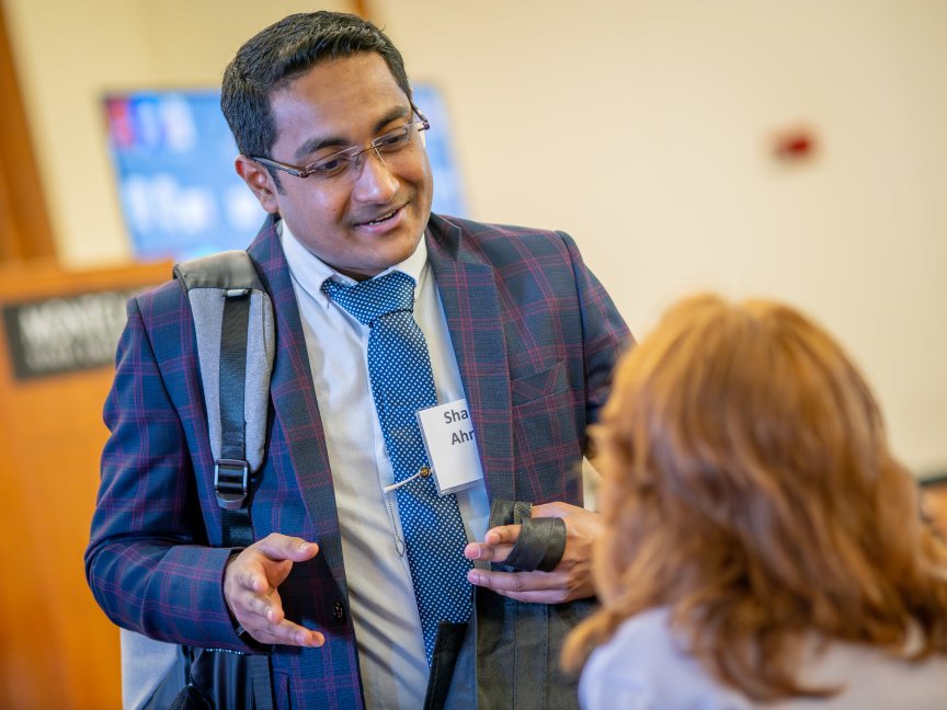 Two students talk to each other while attending a conference