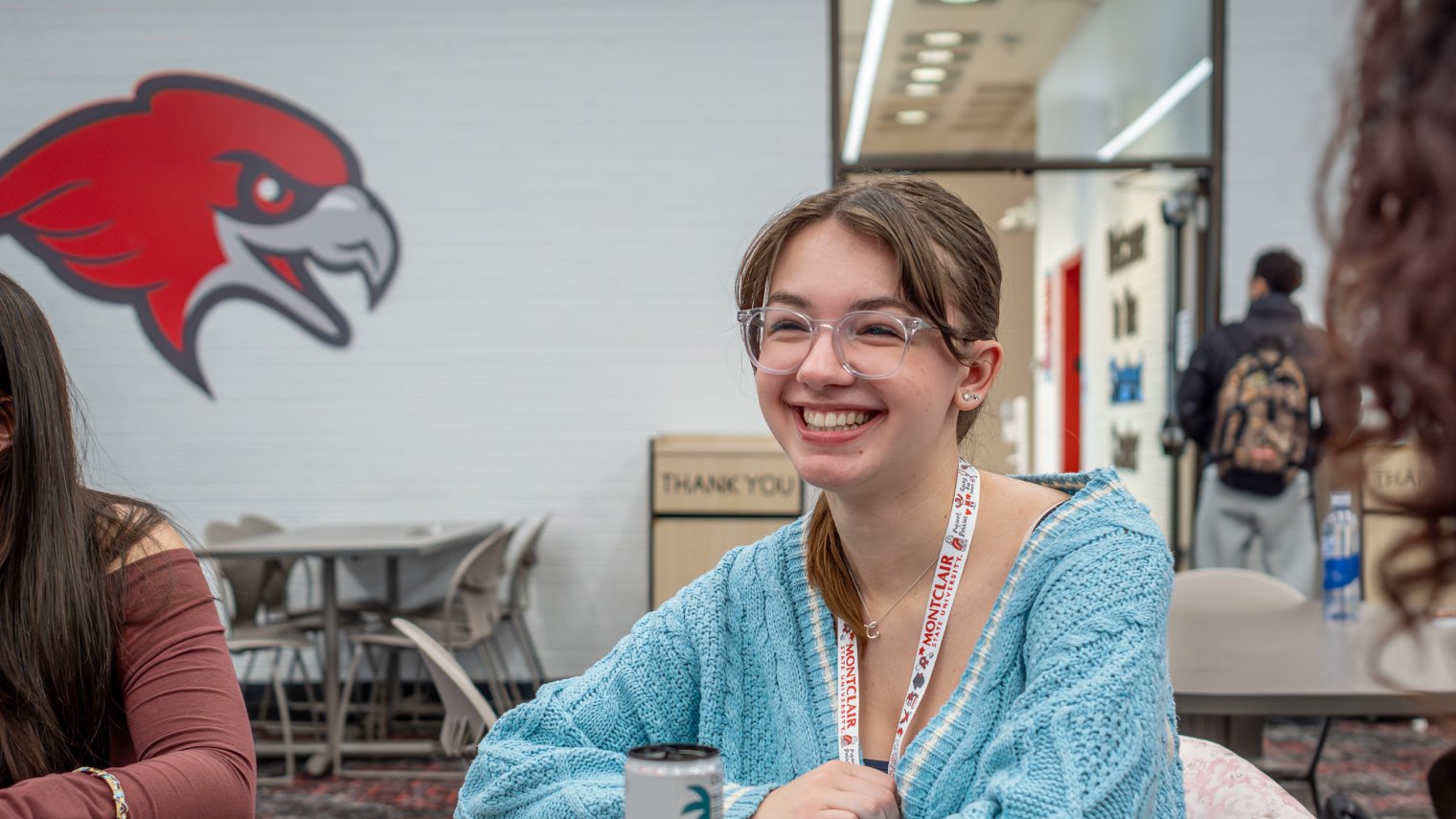 student sitting at table smiling