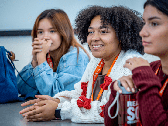 Three students at a table in a classroom