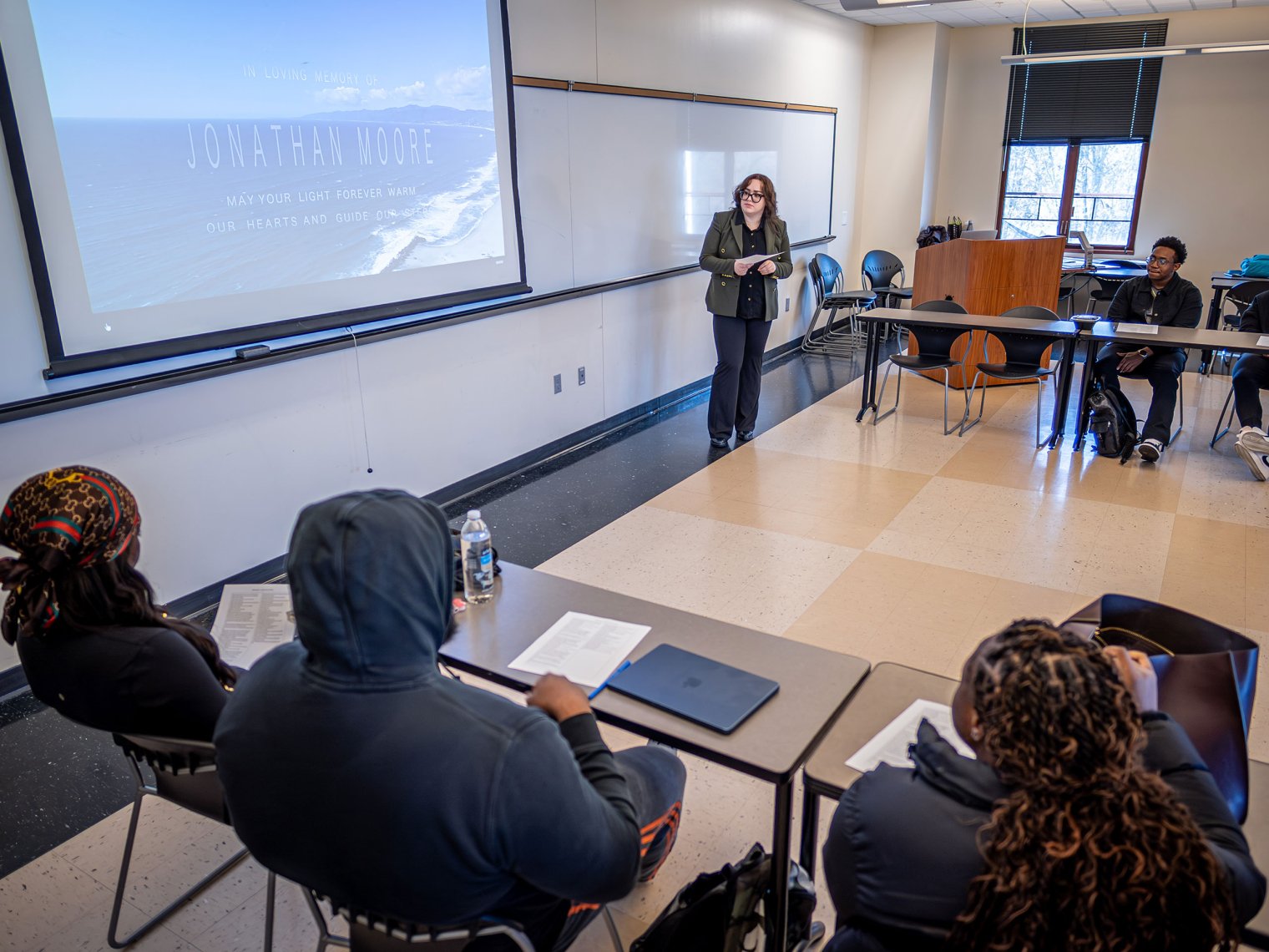Ana Barahona stands at the front of a Montclair classroom as an assistant, looking at a whiteboard while teaching the class.