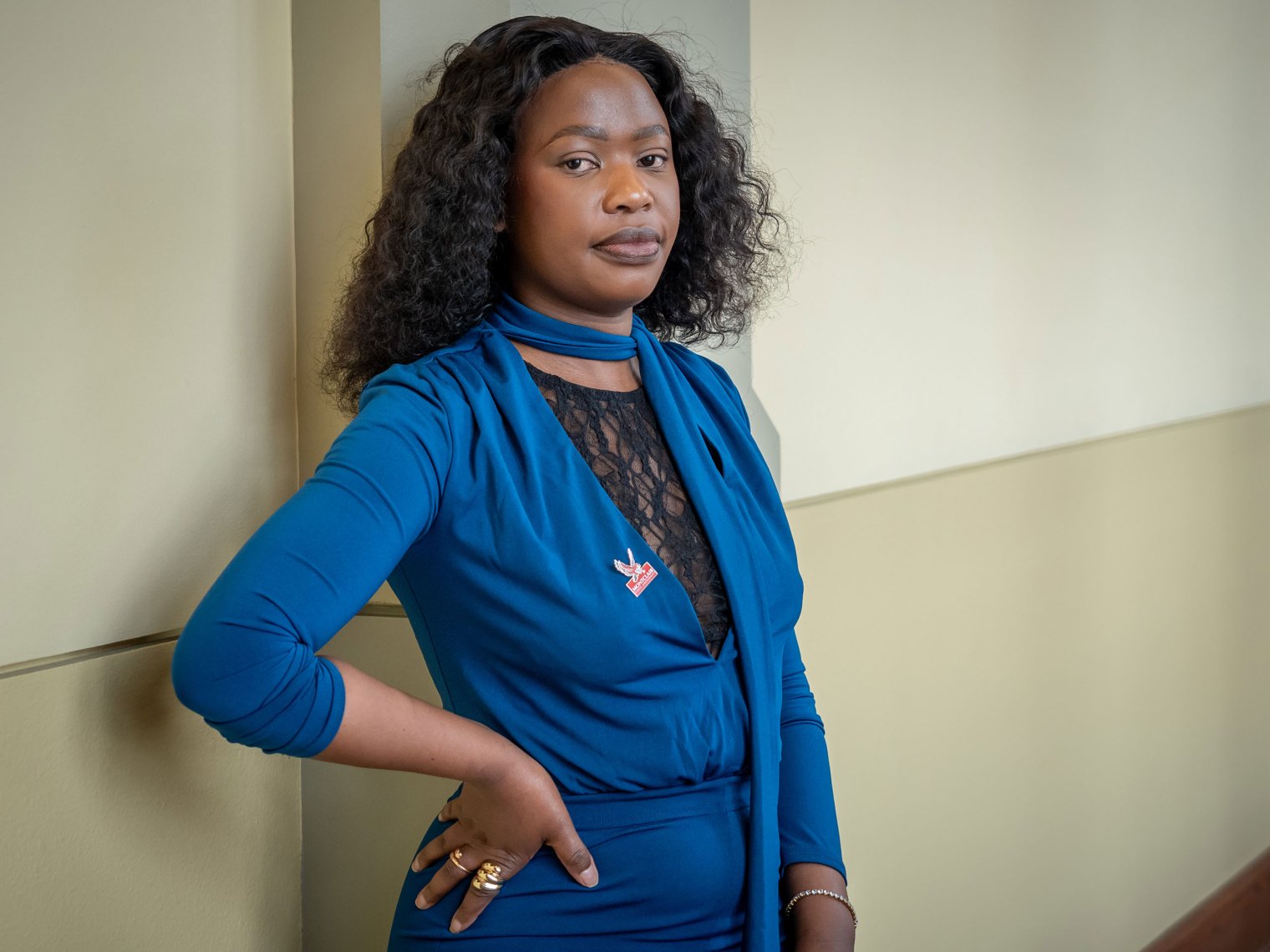 Kananelo Mokati, in a blue top and pants, stands against a wall with a hand on her hip.