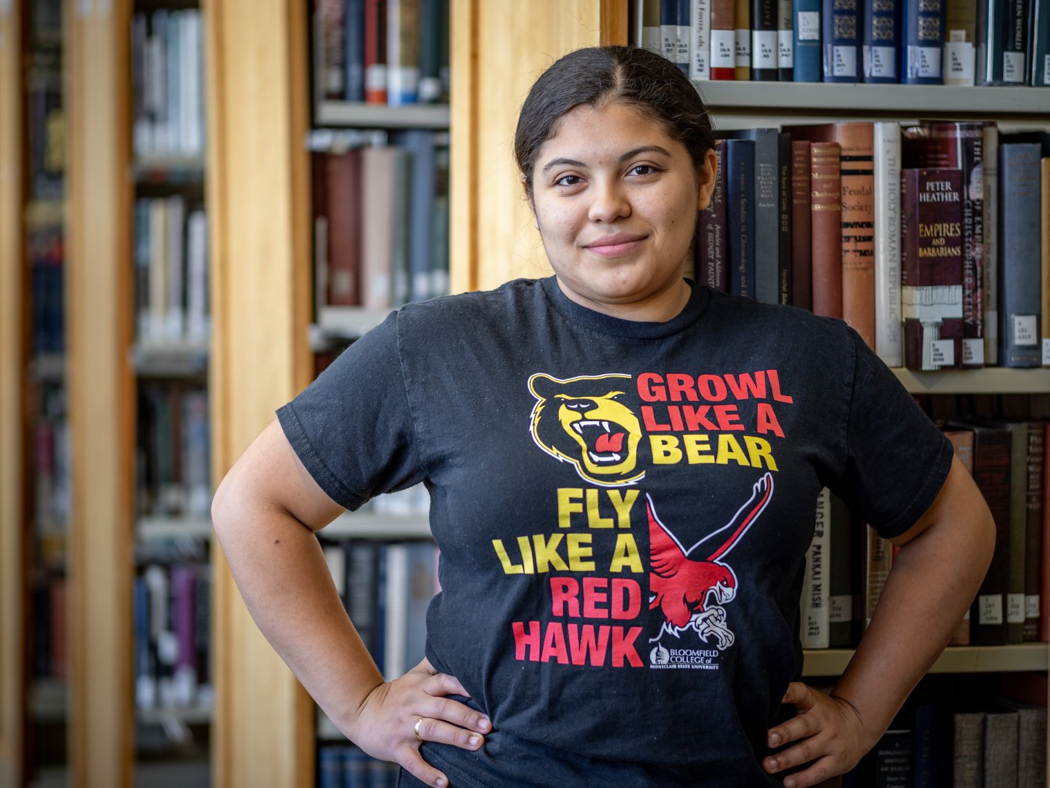 Odyeli Ramos Tobar posing with her hands on her hips with a BC and MSU shirt on.