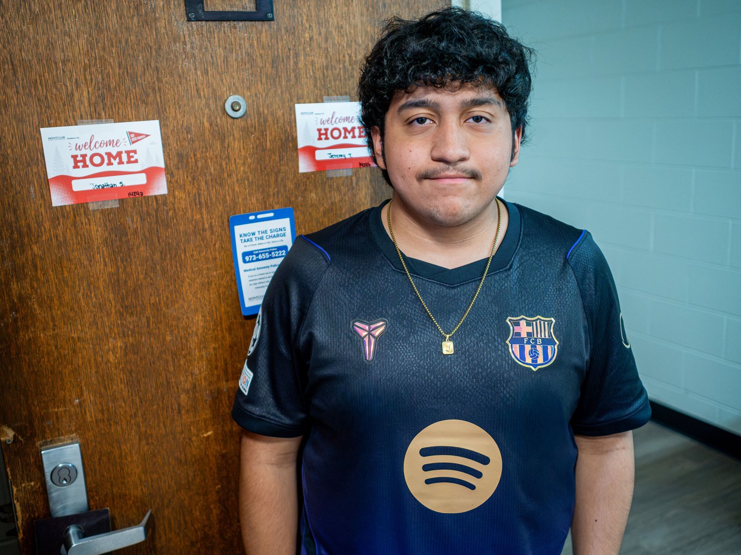 Jeremy Torres stands by his dorm room door.