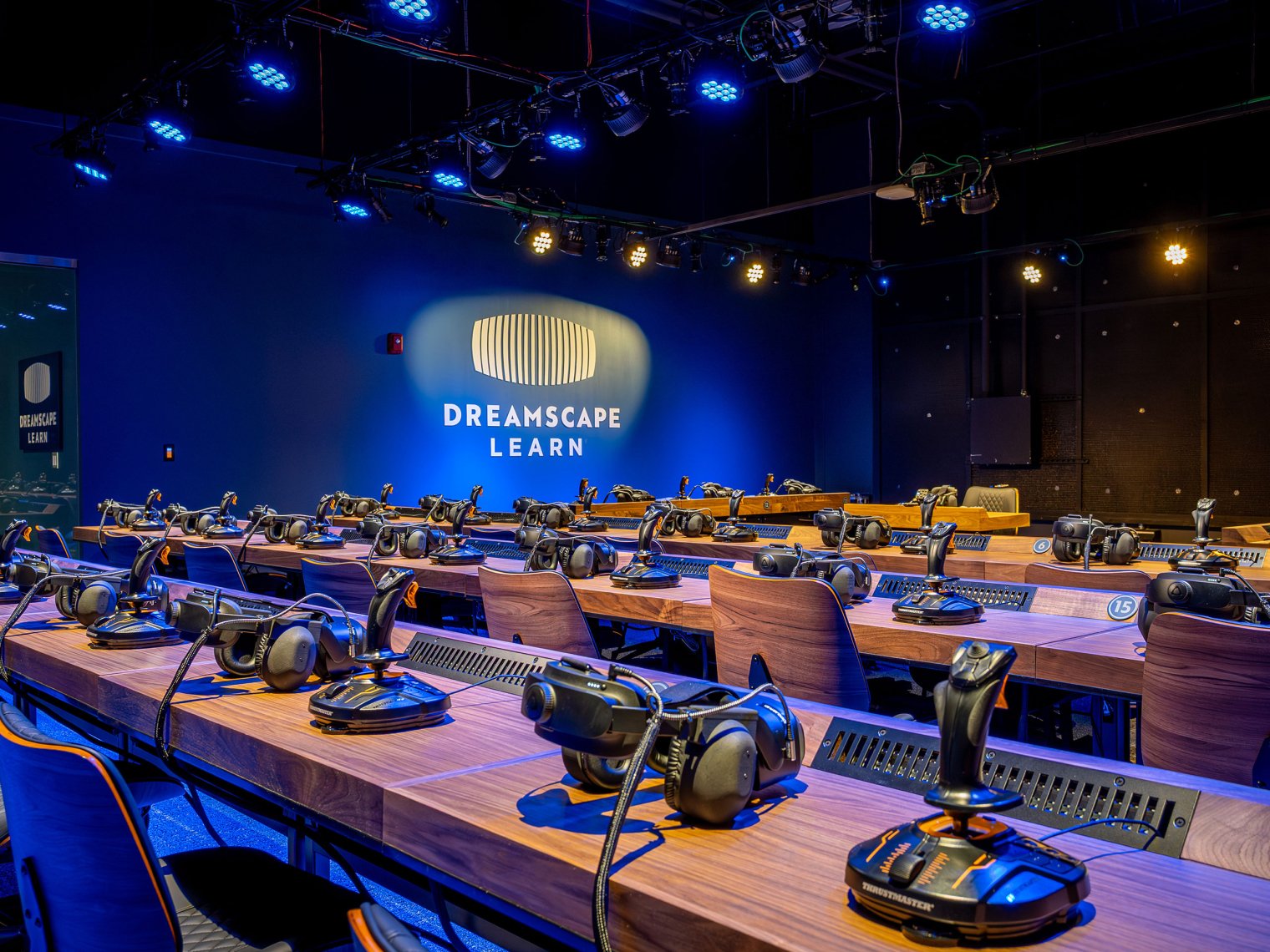View of Dreamscape space showing VR headsets and joysticks arrayed on bench desks