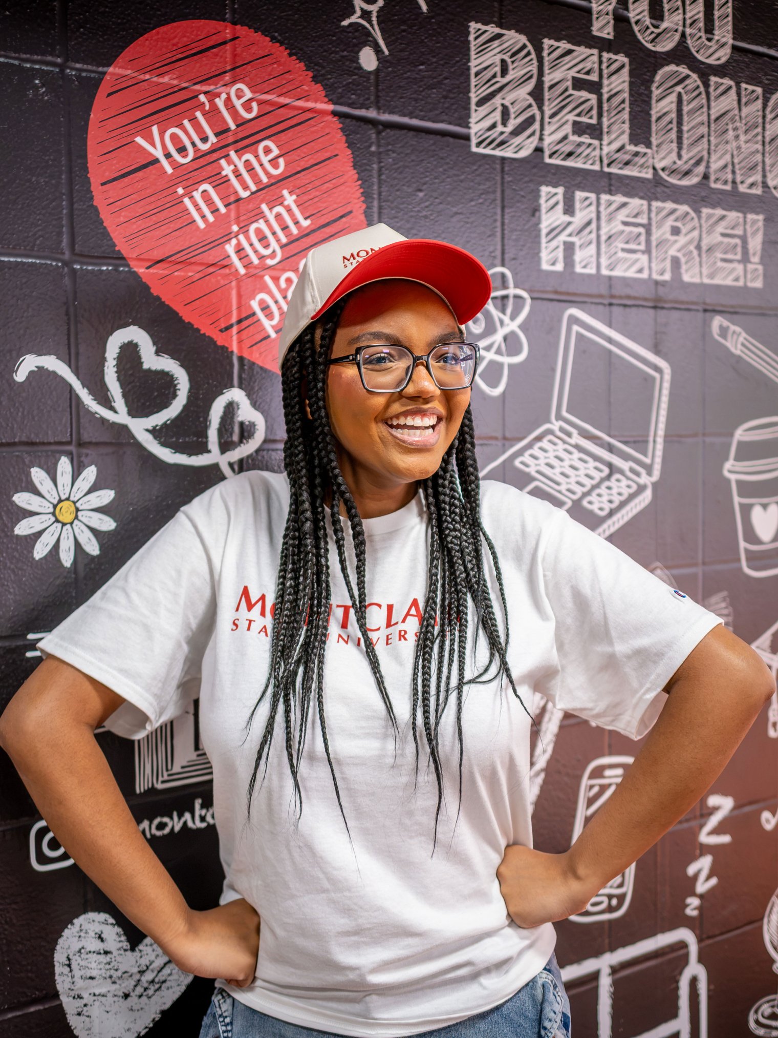 Makiyah Matthews smiling at the camera, wearing a white Montclair t-shirt and matching hat